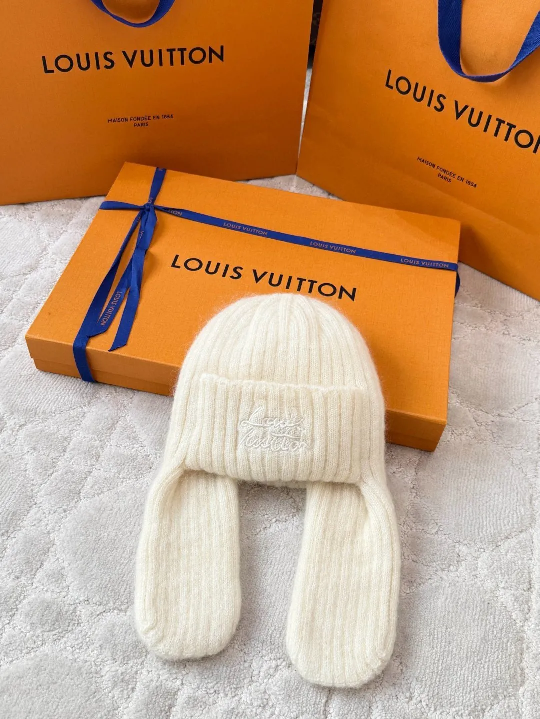 LOUIS VUITTON Autumn and Winter Ski Series Lei Feng Hat ●Original version: 5100 purchase and development ●Item number: 1681971-B05 ●Fabric: wool blended fabric ●Technology: knitted ●Color: white/black/Iceland blue/ ●Version: suitable fit ●Description: Woven by 32-needle fine knitting technology, the suede surface is fluffy and smooth, and its warmth retention is better than ordinary wool hats. The main body of the hat has a vertical grooved stripe texture, which is elastically fit through the fixed-needle shrinking technique. It is suitable for most headbands. The front logo of the hat is made of three-dimensional satin embroidery. The embroidery thread is made of high-gloss yarn of the same color. The stitch density reaches 80 stitches/square centimeter. The pattern is full and not easy to pilling. The ear protection part is woven in one piece, without splicing gaps, making it more comfortable to wear. The finished product is shaped by low-temperature steam to ensure that the hat shape is stiff and not easily deformed. The post-finishing process includes anti-pilling treatment, taking into account both texture and durability. The overall wiring is straight and delicate, the fabric is comfortable and soft, and the color is consistent without color difference. It can be matched with the same style to create a fashionable look and control various occasions. Customized accessories, complete with three standards, same style for men and women!